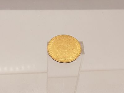une pièce d'or posée sur un socle transparent