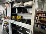 a large open cabinet in a garage with many items on it