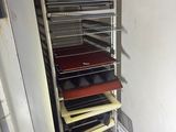 an image of a rack of pizzas in a kitchen