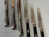 five knives and a knife holder on a table