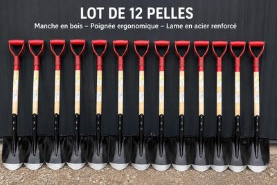 a bunch of shovels are lined up in front of a building
