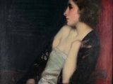 portrait of a woman in a black dress sitting in a red chair