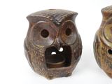 two owl figurines sitting next to each other on a white surface