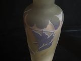 un vase en verre orné d'un oiseau sur fond noir
