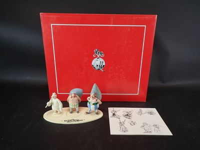 Les figurines sont posées sur la table, devant une boîte rouge.