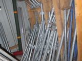 a pile of metal pipes in a room with a shelf
