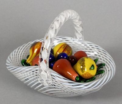 a white basket filled with fruit and vegetables on a table