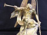 bronze statue of a fairy sitting on a rock with a bow and arrow