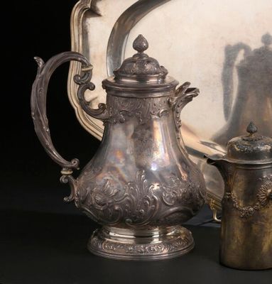 une théière en argent à côté d'un plat en argent et d'un miroir