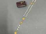 a close up of a rosary and a wallet on a table
