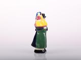 a figurine of a woman with a yellow hat and a green dress