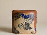 un récipient marron et bleu orné d'un motif floral