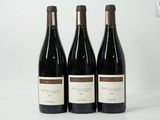 trois bouteilles de vin posées sur une table blanche