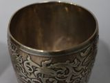 a silver cup sitting on top of a white table