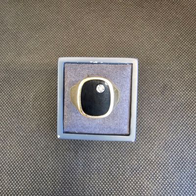 une image représentant une bague sertie d'une pierre noire