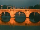 un pont sur lequel se trouvent des statues, enjambant l'eau