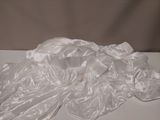 un objet blanc posé sur une table recouverte d'une nappe blanche