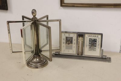 a silver clock sitting on top of a table next to a picture frame