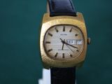 a gold wrist watch with a black leather strap