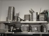 de nombreuses casseroles et poêles sur les étagères de la cuisine