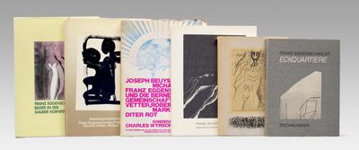 several books are stacked on top of each other on a white surface