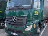deux camions verts garés sur un parking
