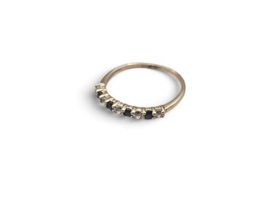 a gold ring with black diamonds on a white background