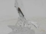 a glass sculpture of a bird sitting on top of a base