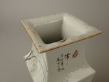 a white vase with chinese writing on it on a table