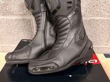 the motorcycle boots are on top of the box on the table