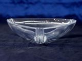 a clear glass bowl with a silver rim on a black surface