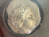 a silver coin with a head of a man on it