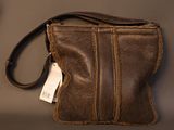 brown leather purse with a tag on it sitting on a table
