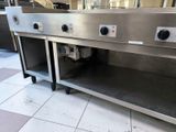 a stainless steel counter with three burners on top of it