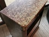 a small wooden table with a marble top on a hard wood floor
