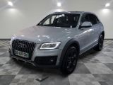 L'Audi QX est garée sur un sol à damier dans un garage.