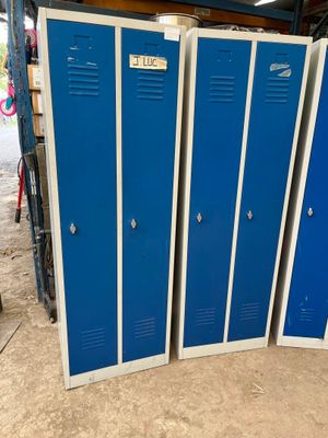 Trois casiers métalliques bleus sont empilés dans un garage