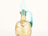 a glass vase with a blue handle on a white background