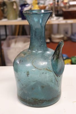 a blue glass vase sitting on a table in a room