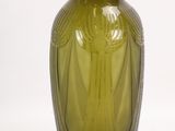 un vase vert posé sur une surface blanche