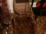 a glass table with a mirror on top of it next to a chair