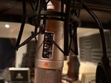 microphone in a recording studio with headphones on and a microphone in the foreground