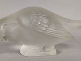 un oiseau en verre posé sur une table