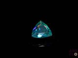 a close up of a blue diamond on a black surface