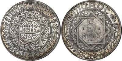 a silver coin with a design on the front and back of it