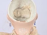a small doll that is holding a cup in it ' s hands