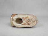 a white vase with a hole in it on a table