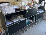 un bureau recouvert de nombreux papiers, dans une pièce