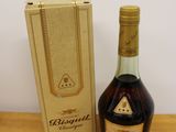 an image of a bottle of brandy sitting next to a cardboard box