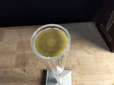 un verre rempli de liquide posé sur une table à côté d'une boîte